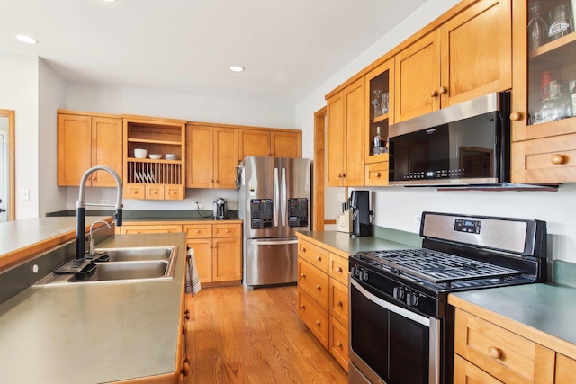 kitchen featuring open shelves, appliances with stainless steel finishes, a sink, recessed lighting, and light wood-type flooring