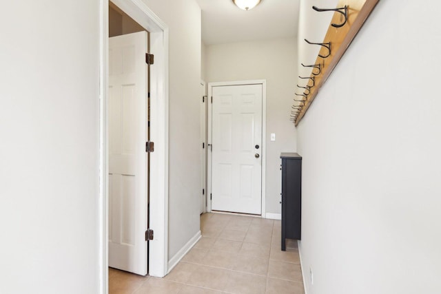 hallway with light tile patterned flooring and baseboards