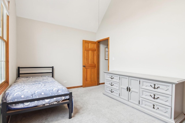 carpeted bedroom featuring baseboards and lofted ceiling