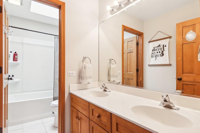 bathroom with a sink, tile patterned flooring, toilet, and double vanity