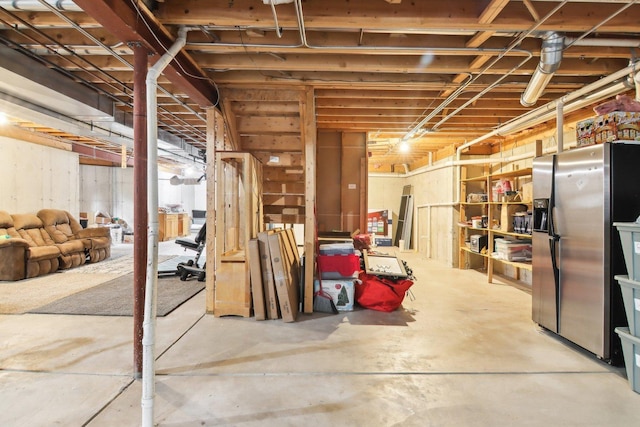 unfinished below grade area featuring stainless steel fridge