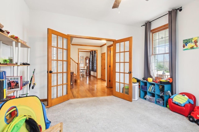 game room featuring a ceiling fan, french doors, and carpet