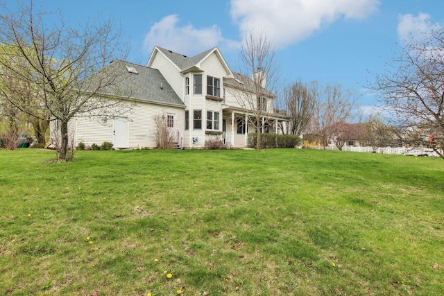 back of property featuring a yard and a chimney