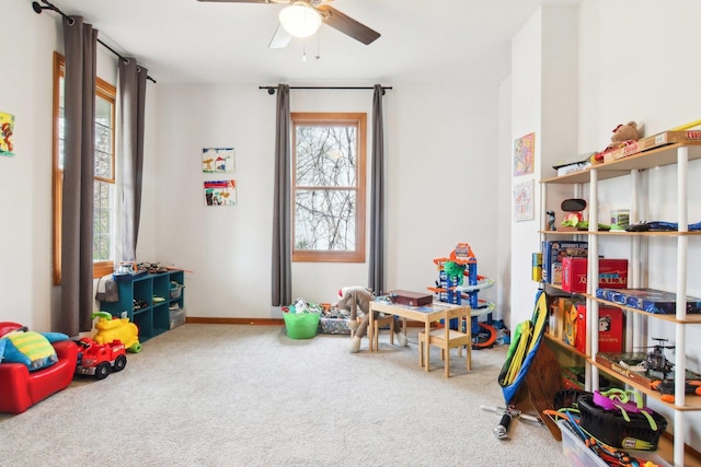 rec room featuring baseboards, ceiling fan, and carpet flooring
