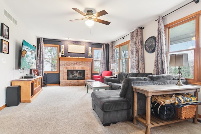 living room with visible vents, ceiling fan, a wealth of natural light, and light colored carpet