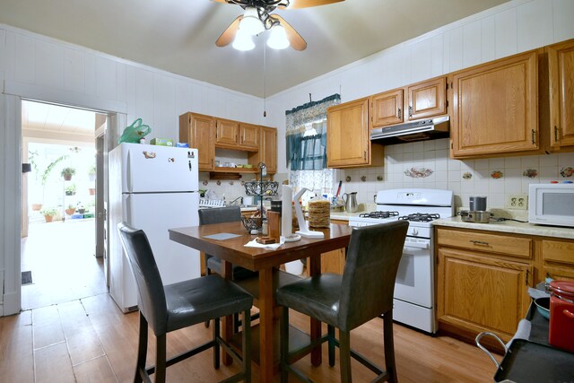 kitchen featuring ceiling fan, white appliances, under cabinet range hood, light wood finished floors, and decorative backsplash