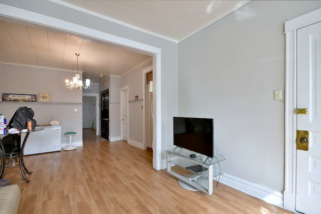 living area with a chandelier, light wood-style floors, baseboards, and crown molding