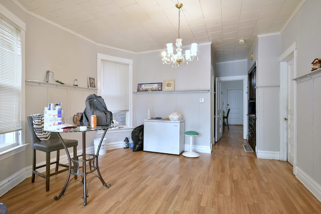 dining area with crown molding, an inviting chandelier, visible vents, wood finished floors, and baseboards