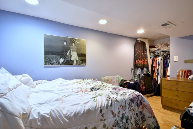 bedroom featuring visible vents, a closet, a spacious closet, recessed lighting, and light wood-style flooring