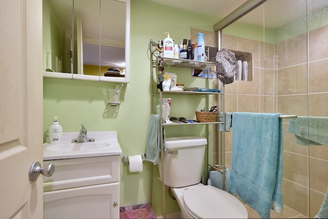full bathroom featuring toilet, a tile shower, and vanity