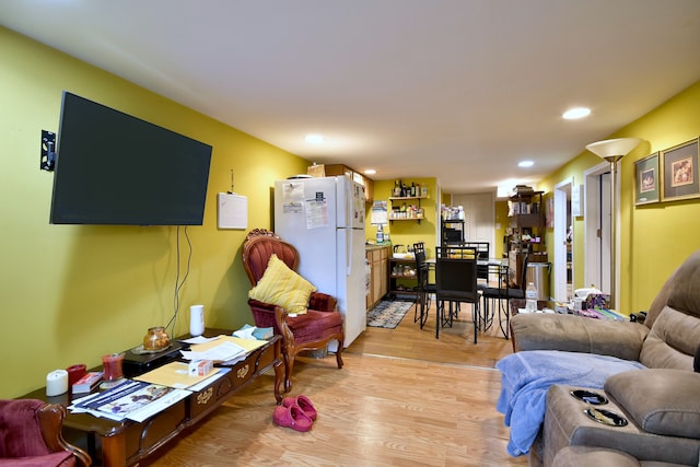 living area with recessed lighting and light wood-style floors