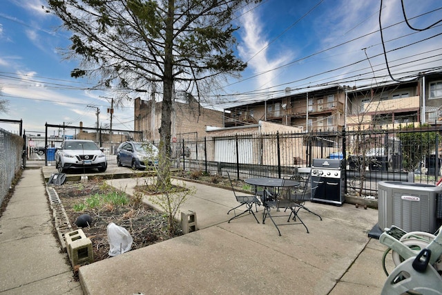 view of patio with central AC, fence, and a grill