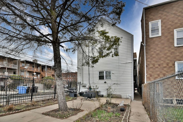 view of side of home with fence and a patio
