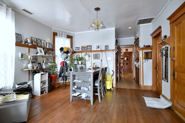 dining room with ornamental molding, visible vents, a chandelier, and wood finished floors