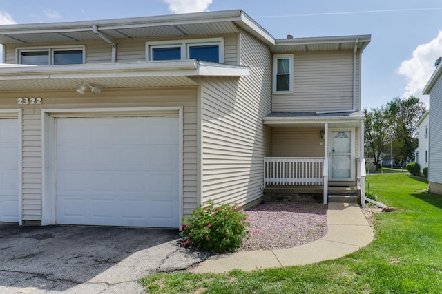 townhome / multi-family property with a garage, a porch, a front lawn, and aphalt driveway