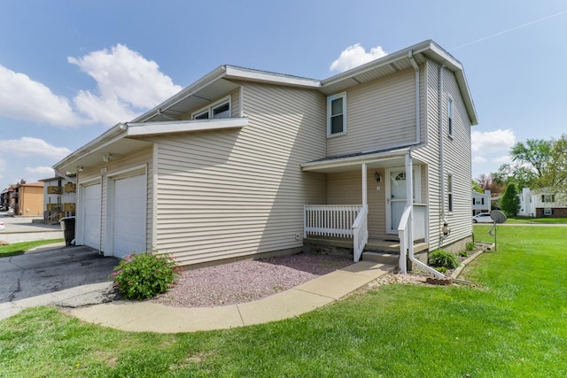 exterior space featuring an attached garage, a front lawn, and driveway