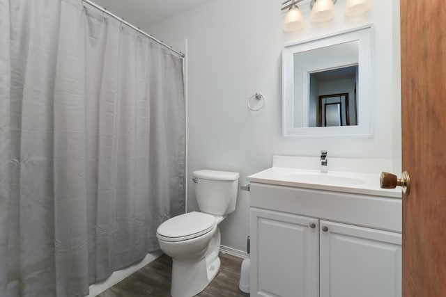 full bath with wood finished floors, curtained shower, vanity, baseboards, and toilet