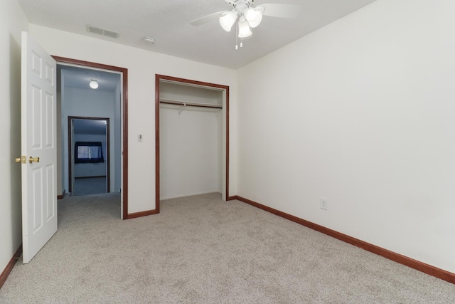 unfurnished bedroom with baseboards, light carpet, a closet, and visible vents