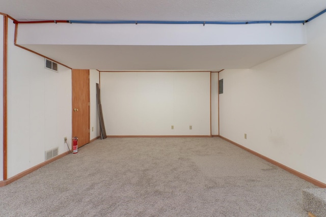 finished basement with baseboards, carpet, and visible vents