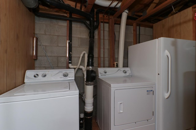 washroom featuring separate washer and dryer, laundry area, and concrete block wall