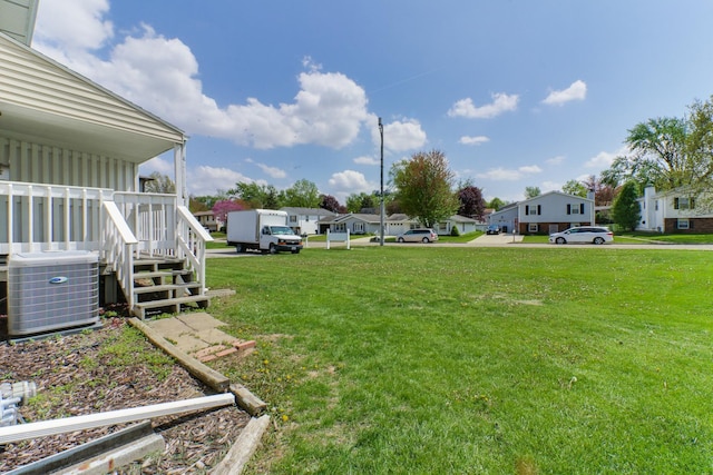 view of yard with a residential view and central AC unit
