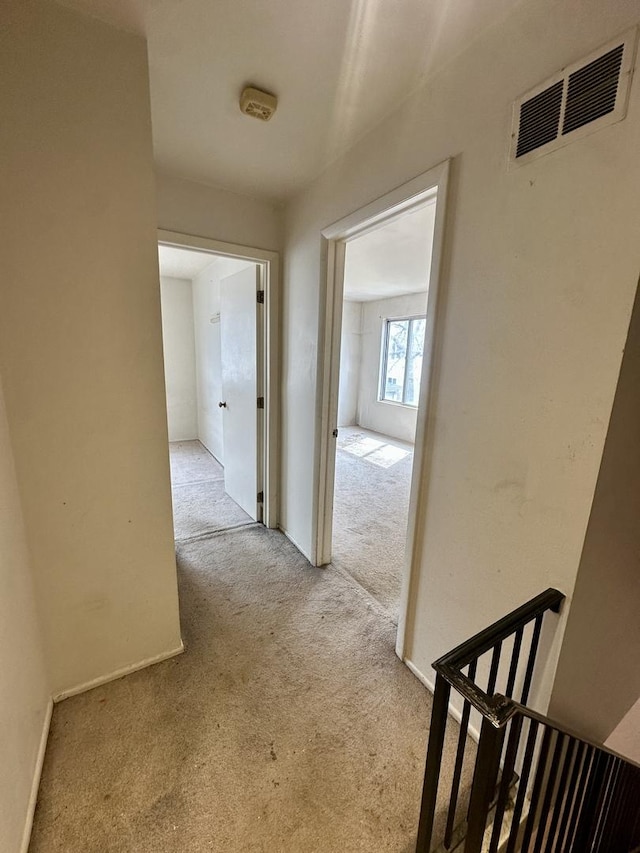 corridor featuring carpet flooring and visible vents