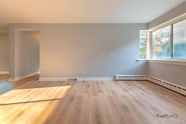 2051 E 72nd St Unit 1B, Chicago, IL 60649 - empty room with a baseboard heating unit, wood finished floors, and a ceiling fan