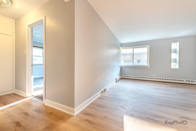 2051 E 72nd St Unit 1B, Chicago, IL 60649 - unfurnished room featuring a baseboard radiator, plenty of natural light, and light wood-style flooring