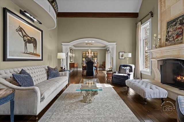 36W442 Hunters Gate Rd, Saint Charles, IL 60175 - living area with arched walkways, a lit fireplace, dark wood finished floors, a chandelier, and a towering ceiling