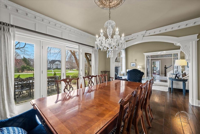 36W442 Hunters Gate Rd, Saint Charles, IL 60175 - dining area featuring arched walkways, dark wood finished floors, a chandelier, and a large fireplace