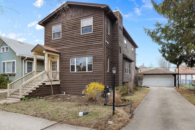 view of front of property with a garage, fence, and an outdoor structure
