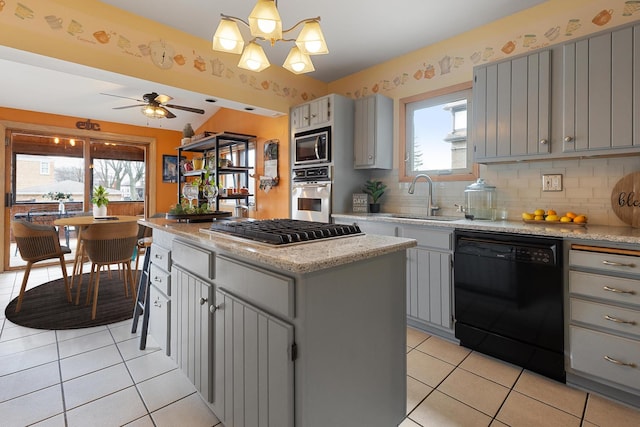 kitchen with light tile patterned floors, a kitchen island, appliances with stainless steel finishes, a sink, and gray cabinetry