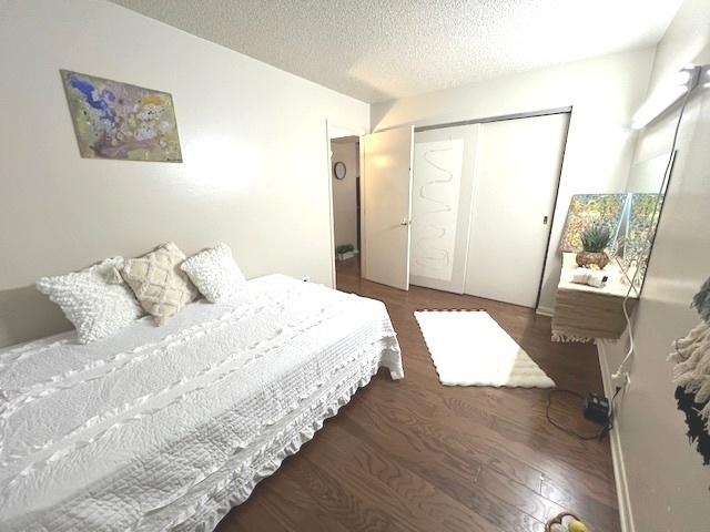 bedroom featuring a textured ceiling, a closet, and wood finished floors