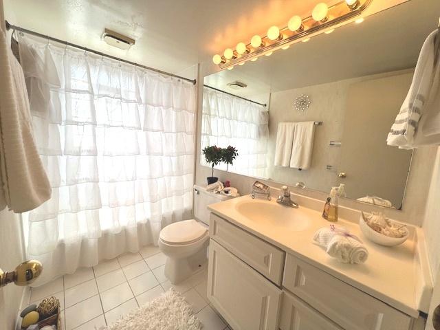 full bath featuring shower / tub combo, a wealth of natural light, tile patterned flooring, and vanity