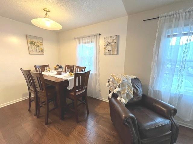 dining space featuring baseboards, a textured ceiling, and dark wood-style floors