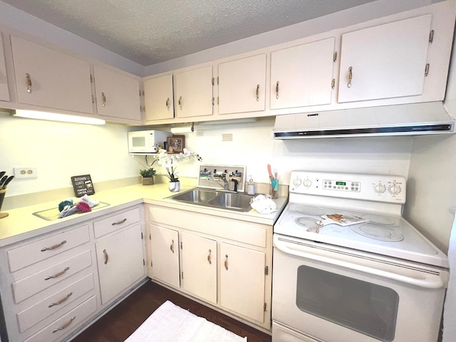 kitchen featuring white appliances, light countertops, a textured ceiling, a sink, and ventilation hood