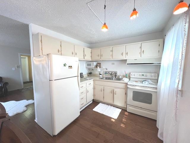kitchen featuring a sink, ventilation hood, white appliances, and a textured ceiling