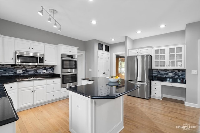 kitchen featuring stainless steel appliances, white cabinetry, backsplash, light wood-style floors, and recessed lighting