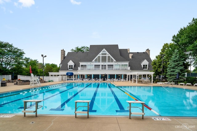 community pool with a patio and fence