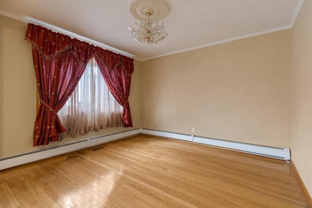 empty room with baseboards, wood finished floors, an inviting chandelier, and ornamental molding