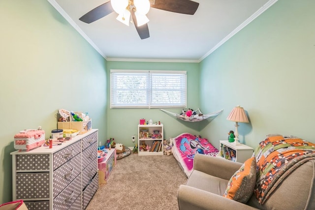 recreation room featuring ceiling fan, ornamental molding, and carpet