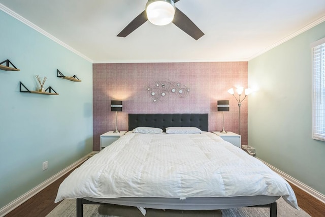 bedroom featuring an accent wall, crown molding, baseboards, and ceiling fan