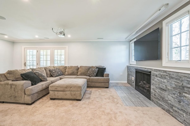 carpeted living area featuring crown molding, a stone fireplace, recessed lighting, and a healthy amount of sunlight