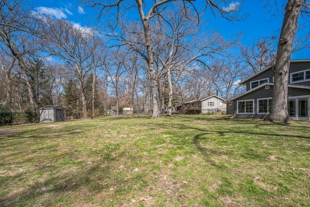 view of yard featuring fence, an outbuilding, and a storage unit
