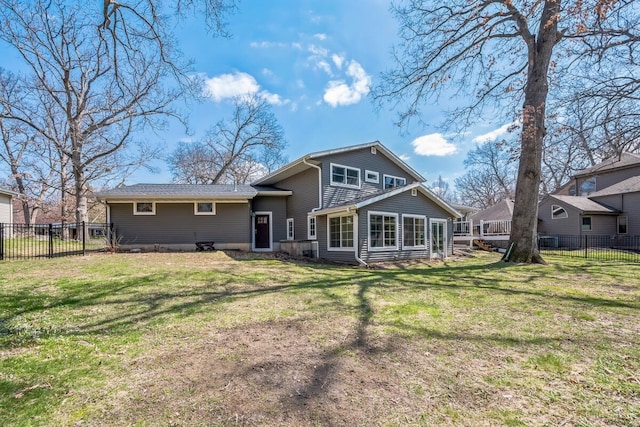 back of house with a fenced backyard and a yard