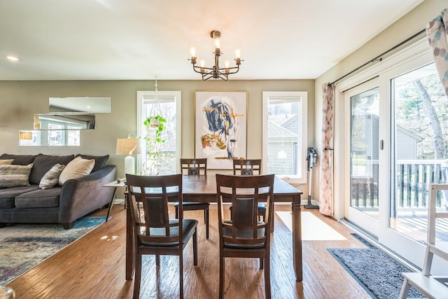 dining space with a chandelier, wood finished floors, and baseboards