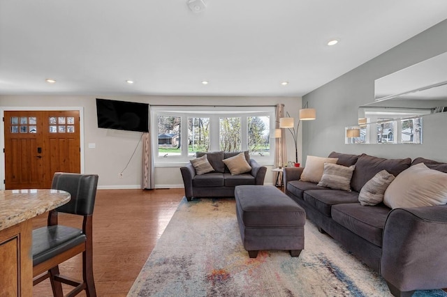 living area with recessed lighting, light wood-style flooring, and baseboards
