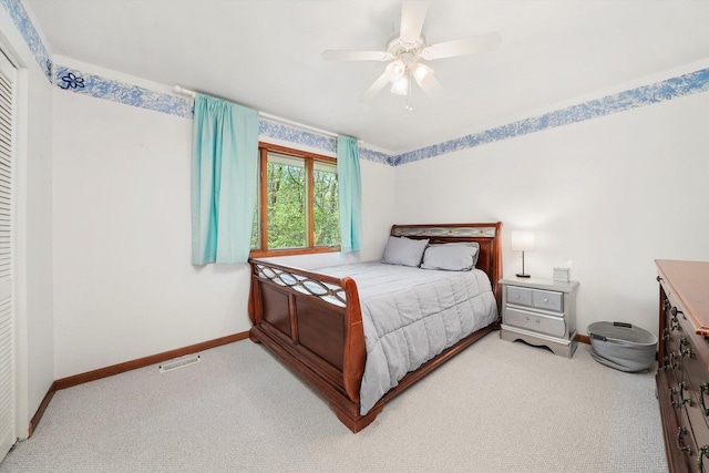 bedroom featuring baseboards, light colored carpet, and a ceiling fan
