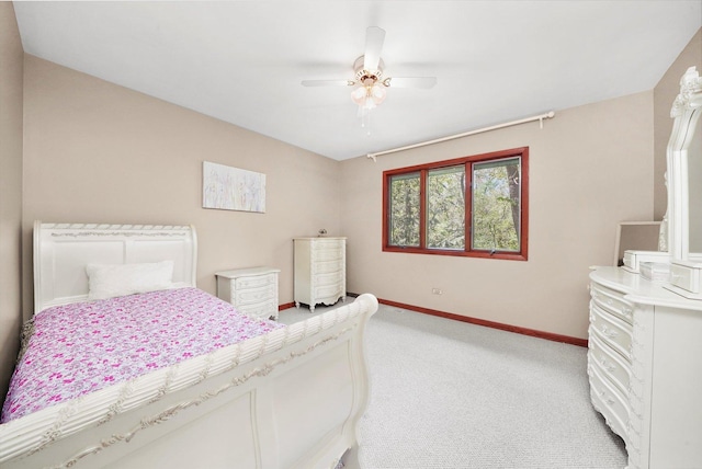 bedroom featuring light colored carpet, baseboards, and a ceiling fan