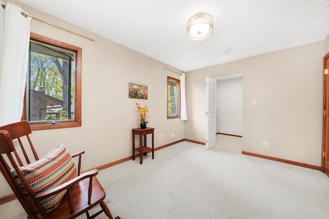 living area with light carpet and baseboards